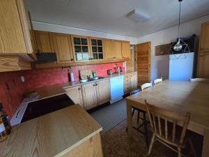 a kitchen with wooden cabinets and a table with chairs at Brendefur Panorama in Hornindal