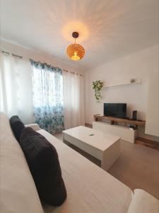 una sala de estar con un sofá y una mesa en Alquilaencanarias Medano Lago Azul, en El Médano