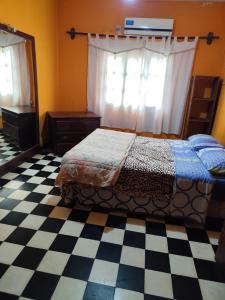 Un dormitorio con una cama y un suelo de cuadros. en Hostal Orán, en San Ramón de la Nueva Orán