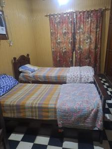 Dos camas una al lado de la otra en una habitación. en Hostal Orán, en San Ramón de la Nueva Orán