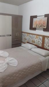 Un dormitorio con una cama grande y una cómoda. en Residencial Três Irmas, en Florianópolis