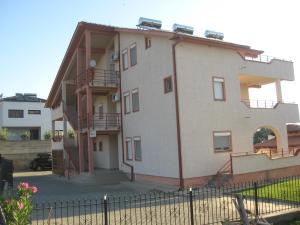 a building with a fence in front of it at Apartmani Marija in Star Dojran