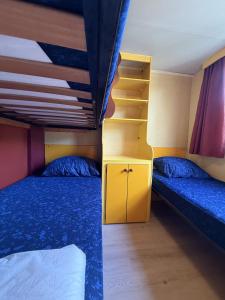 a bedroom with two beds and a bunk bed at Camping Paradiso - Aranciona 7 in Viareggio