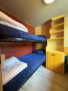 a room with two bunk beds and a desk at Camping Paradiso - Aranciona 7 in Viareggio