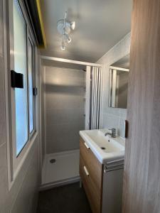 a white bathroom with a sink and a shower at Camping Paradiso - Aranciona 7 in Viareggio