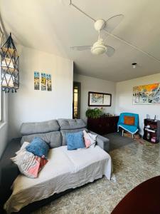 uma sala de estar com um sofá e uma cadeira azul em Quarto com ar condicionado em apt compartilhado e estacionamento grátis em Niterói