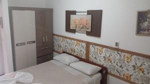 1 dormitorio con 1 cama y armario con 2 almohadas en Residencial Três Irmas, en Florianópolis