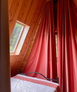 a bed in a room with a red curtain at Mtis Racha in Oni