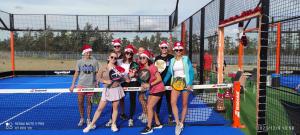 a group of people wearing santa hats standing on a tennis court at Barefoot Beach House in Larnaka