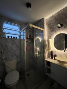 um banheiro com chuveiro, vaso sanitário e pia em Quarto com ar condicionado em apt compartilhado e estacionamento grátis em Niterói mais 16 fotografias