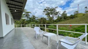 a balcony with two chairs and a table at Aguas Claras casa campestre in Las Cruces