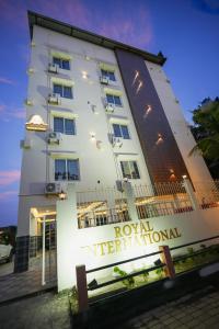 Un edificio blanco con un cartel delante. en Hotel Royal International - Best Boutique Hotel Near Airport & Kamakhya Temple, en Guwahati