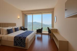 a hotel room with a bed and a large window at Luxe' Vista by Z Vacations in Kodaikānāl
