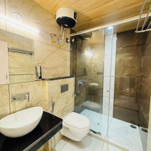 a bathroom with a toilet and a sink and a shower at Jasmine Mountain View Retreat - Mall Road Dalhousie in Dalhousie