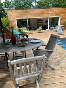 a wooden deck with a table and two chairs at Maison à 10 min d'Angers in Mûrs-Érigné