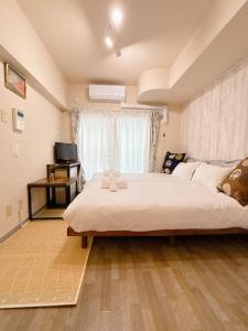 una camera da letto con un letto grande e una finestra di アパートホテルMk札幌駅前 a Kita-rokujō