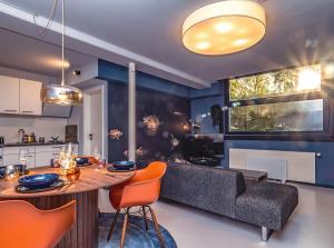 a kitchen and living room with a table and a couch at Wunderschönes Loft-Apartment im grünen Hamburg in Hamburg