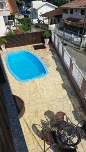 una piscina in un cortile con patio in pietra di Suíte próximo a Vila Germânica a Blumenau Altre 4 foto