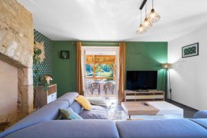 a living room with a blue couch and a tv at Maison de vacances Avec Piscine in Loubejac