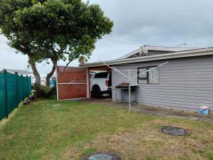 a white truck parked in a garage next to a house at Die Dam Chalet in Pearly Beach