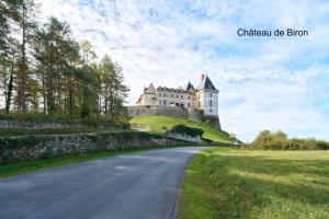 a castle on top of a hill with a road at Maison de vacances Avec Piscine in Loubejac