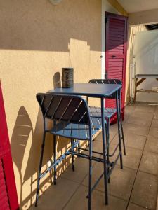 una mesa azul y sillas sentadas junto a una pared en Azursalsa, en Roquefort-les-Pins