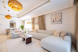 a living room with couches and a table at Coastal Luxury 4BR Apartment with Private Balcony in Abu Dhabi +58 photos