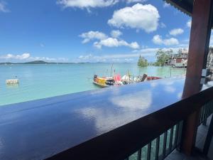 a view of a boat in the water from a balcony at Sunrise House at Lanta in Ban Nong Chaeng
