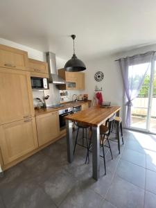 cocina con mesa de madera y ventana grande en Azursalsa, en Roquefort-les-Pins