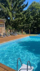 a swimming pool with chairs next to a wooden deck at Wellness Retreat Glamping - Adults Only - Forest & Valley in Pirkenhammer