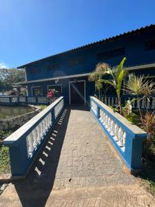 a blue house with a white fence in front of it at Espaço Krisalys in Guararema