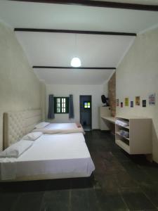a large bedroom with two beds and a window at Espaço Krisalys in Guararema