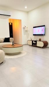 a living room with a couch and a tv at SkyPark One Islamabad Sapphire Suite in Islamabad