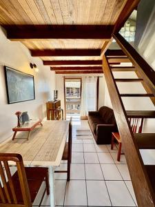 a living room with a wooden table and a staircase at Residencial Solar del Nieto in Garopaba