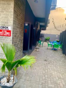 a patio with tables and chairs and a palm plant at CBox Lodge & Lounge in Lagos