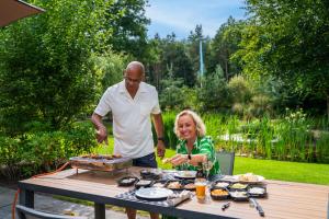 a man and a woman preparing food at a table at Recreatiepark Beekbergen in Beekbergen