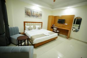 Un dormitorio con una cama, un escritorio y un televisor. en Hotel Royal International - Best Boutique Hotel Near Airport & Kamakhya Temple, en Guwahati