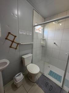 a bathroom with a shower and a toilet and a sink at Residencial Solar del Nieto in Garopaba