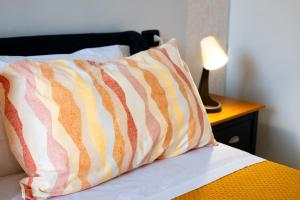 a pillow sitting on top of a bed with a lamp at Civico 23 in Matera