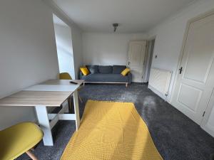 a living room with a blue couch and a yellow rug at Comfortable, London 1 Bed Garden in London +7 photos