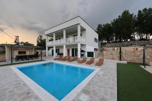 a villa with a swimming pool in front of a house at Villa Vallis with pool in Kruševo