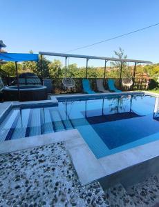a swimming pool with blue chairs at Agava Club in Sremska Kamenica +61 photos
