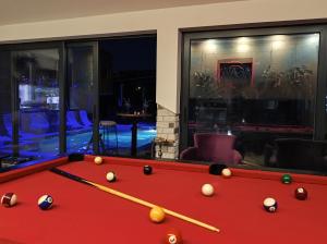 a red pool table with balls on it in a room at Agava Club in Sremska Kamenica