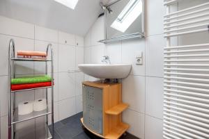 a bathroom with a sink and a towel rack at Ferienwohnung Goelz in Bad Schussenried +13 photos