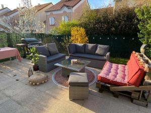 a patio with couches and chairs and a table at Maison avec jardin - entre Paris et Disney in Pontault-Combault