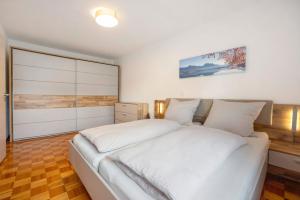 a bedroom with a large bed with white sheets at Ferienwohnung am Mühlbach in Hausen