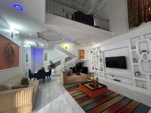 Una sala de estar con un sofá y un televisor. en Effixzzy villa, en Lekki 13 fotos más