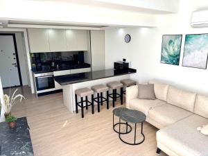 a living room with a couch and a kitchen at Luxurious 1 bedroom duplex apartment in Palmera Resort in Ayios Yeoryios