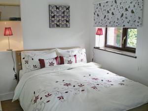 a bedroom with a white bed with red pillows at Bellwood House Annexe in Felixkirk