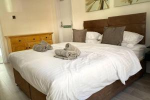 a bedroom with a large white bed with towels on it at Apartment - Sleeps 2 - Parking - WiFi in Newport +4 photos